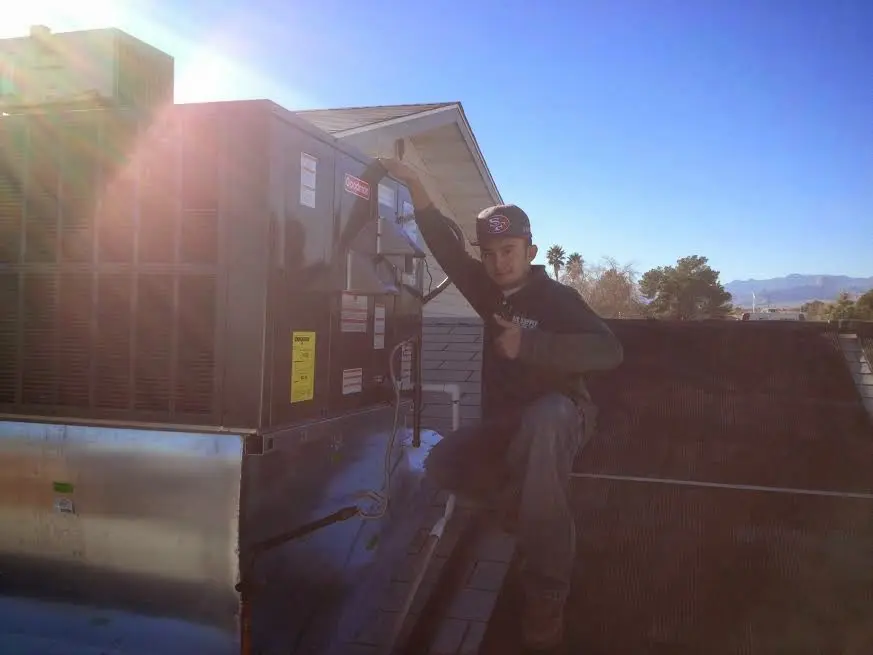 HVAC technician performing AC Tune-Up on a rooftop unit in Las Cruces